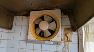 広島市西区鈴が峰での作業前。長年の油汚れがびっしりと付着して茶色くなった換気扇（レンジフード）の内部