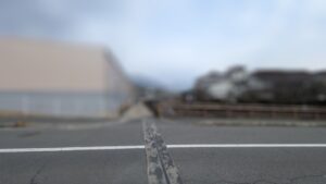 広島市内の駐車場現地調査を行う便利屋万の作業風景。近隣挨拶と現場確認を代行中、予期せぬ問題を解決し、依頼主へ報告するための記録写真。